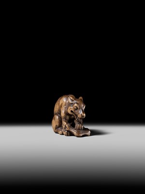 Lot 146 - A FINE WOOD NETSUKE OF A WOLF WITH HAUNCH OF VENISON, ATTRIBUTED TO OKATOMO