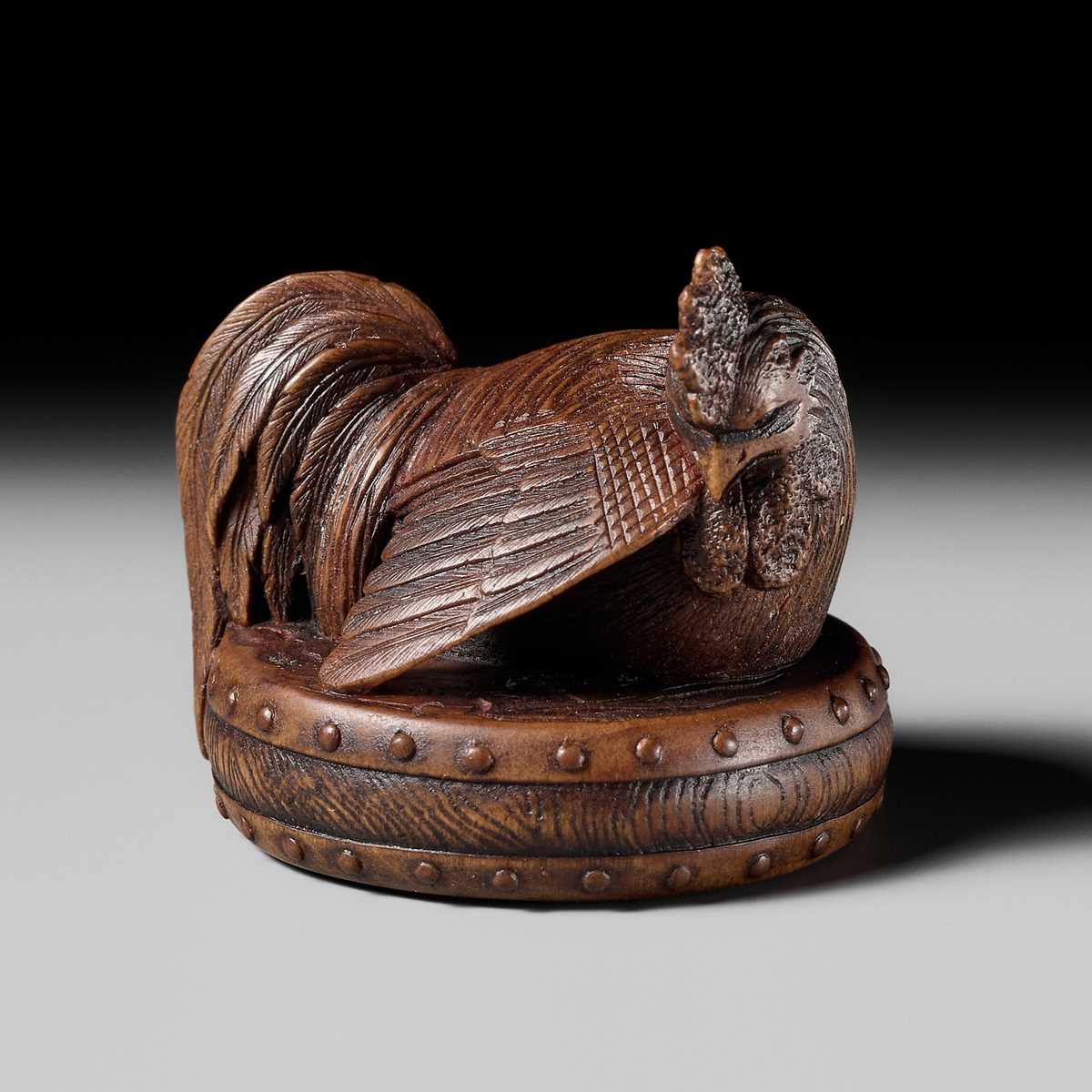 Lot 187 - MASATAMI: A WOOD NETSUKE OF A COCKEREL ON A WAR DRUM