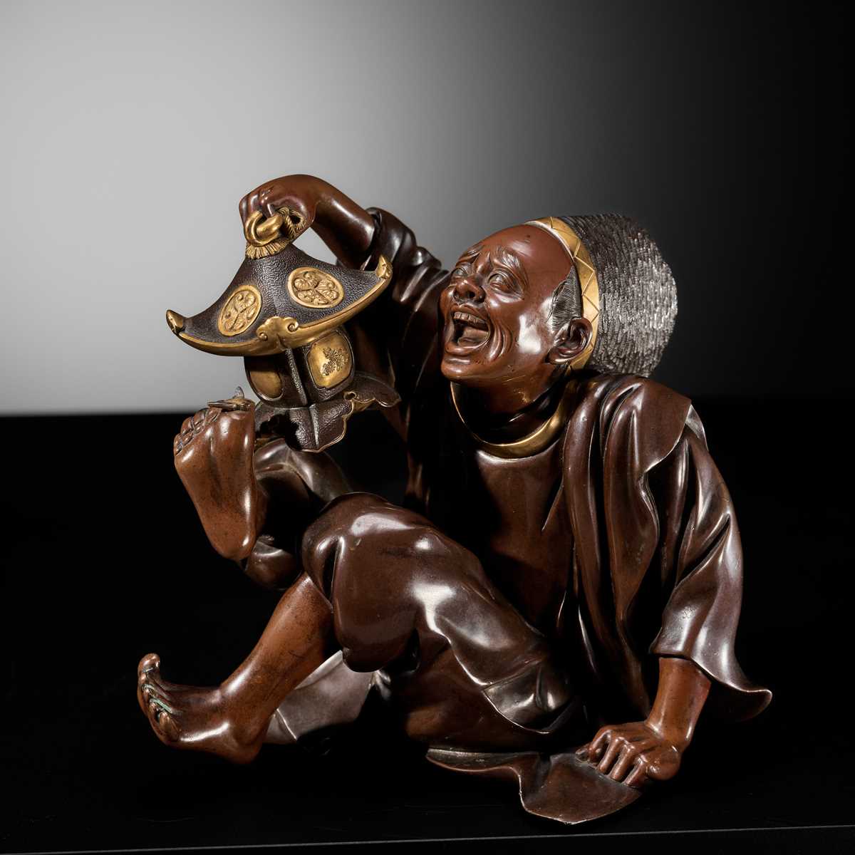 Lot 10 - MASAFUMI: A MIYAO-STYLE PARCEL-GILT BRONZE OKIMONO OF A TEMPLE SERVANT