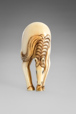 Lot 499 - AN IVORY NETSUKE OF A GRAZING HORSE