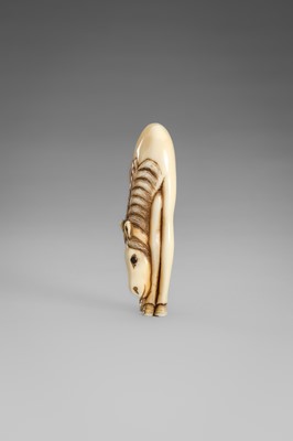 Lot 499 - AN IVORY NETSUKE OF A GRAZING HORSE