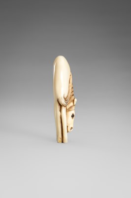 Lot 499 - AN IVORY NETSUKE OF A GRAZING HORSE