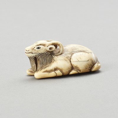 Lot 1633 - AN IVORY NETSUKE OF A RECUMBENT GOAT