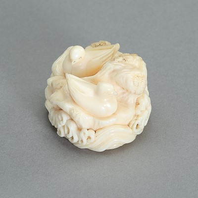 Lot 1634 - A MARINE IVORY NETSUKE OF TWO DUCKS ON A ROCKY PLINTH