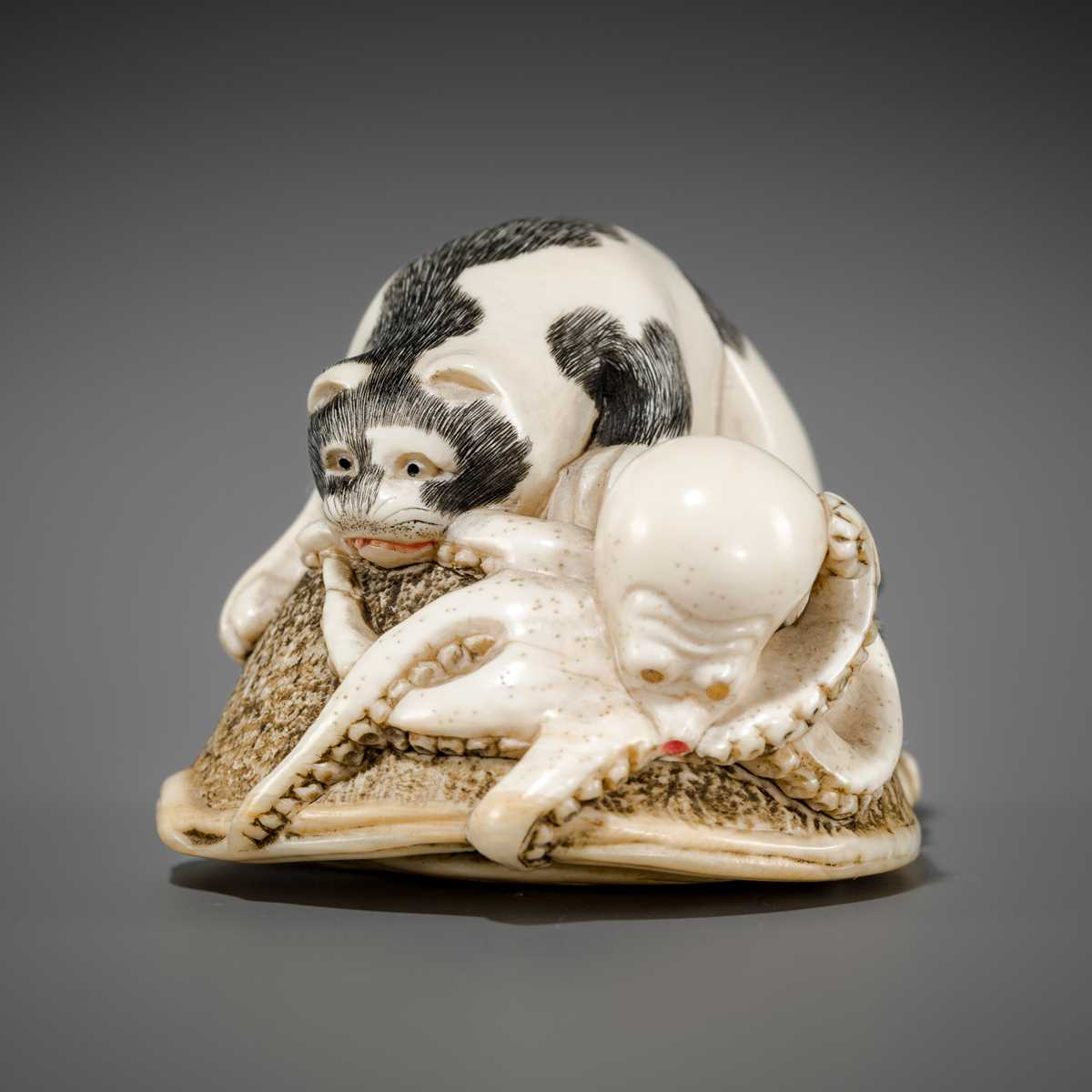 Lot 471 - AN IVORY NETSUKE OF A CAT AND OCTOPUS