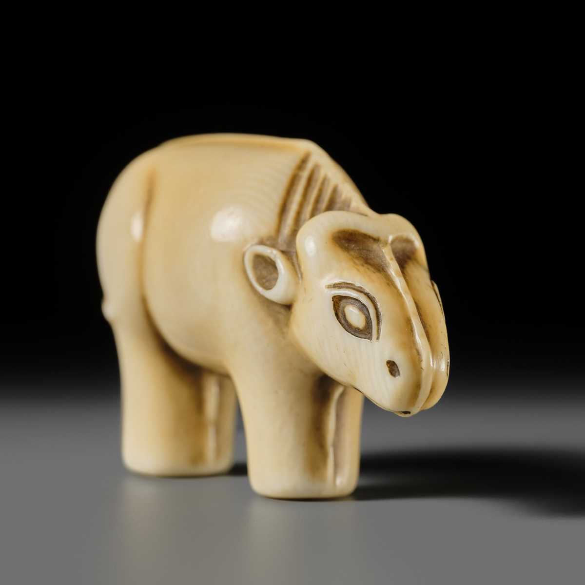 Lot 159 - OHARA MITSUSADA: AN IVORY NETSUKE OF AN OX-FORM OMAMORI