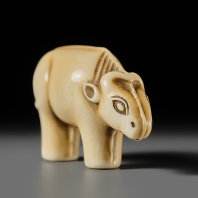 Lot 159 - OHARA MITSUSADA: AN IVORY NETSUKE OF AN OX-FORM OMAMORI