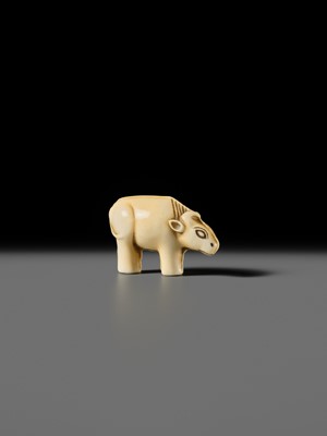Lot 159 - OHARA MITSUSADA: AN IVORY NETSUKE OF AN OX-FORM OMAMORI