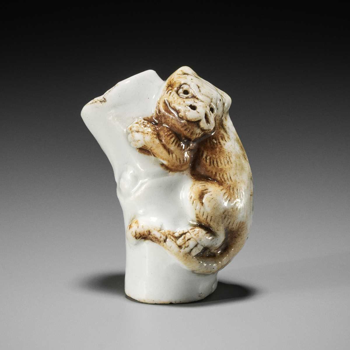 Lot 559 - A HIRADO PORCELAIN NETSUKE OF A TIGER ON BAMBOO