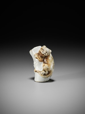 Lot 559 - A HIRADO PORCELAIN NETSUKE OF A TIGER ON BAMBOO