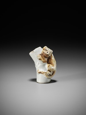 Lot 559 - A HIRADO PORCELAIN NETSUKE OF A TIGER ON BAMBOO