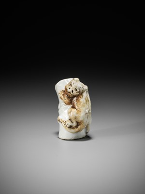 Lot 559 - A HIRADO PORCELAIN NETSUKE OF A TIGER ON BAMBOO