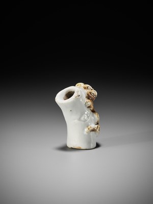 Lot 559 - A HIRADO PORCELAIN NETSUKE OF A TIGER ON BAMBOO