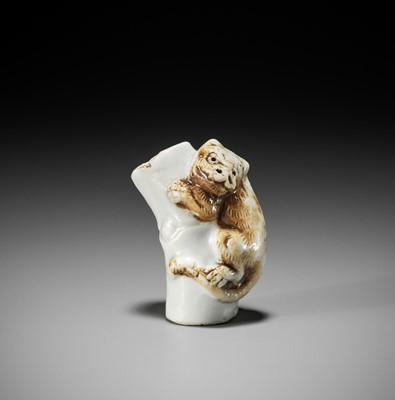 Lot 559 - A HIRADO PORCELAIN NETSUKE OF A TIGER ON BAMBOO