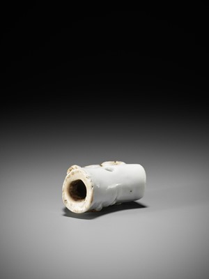 Lot 559 - A HIRADO PORCELAIN NETSUKE OF A TIGER ON BAMBOO