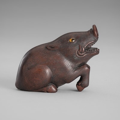 Lot 1566 - A WOOD NETSUKE OF A RECUMBENT BOAR, AFTER TOYOMASA