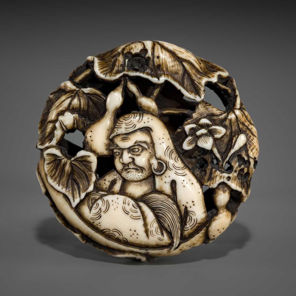 Lot 548 - BUNZAN: A FINE WALRUS TUSK RYUSA MANJU NETSUKE WITH DARUMA AND HYOTAN