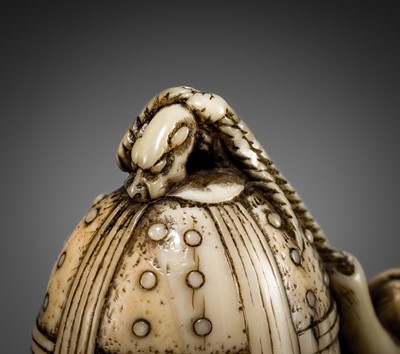 Lot 124 - A FINE KYOTO SCHOOL IVORY NETSUKE OF A MONKEY SCALING A TEMPLE BELL (BONSHO)