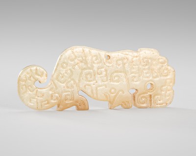 Lot 930 - A PALE CELADON AND BROWN JADE ‘TIGER’ PENDANT, SPRING AND AUTUMN PERIOD