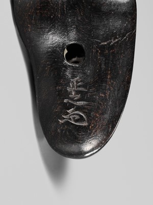 Lot 417 - HOSHUNSAI MASAYUKI: A RARE EBONY WOOD NETSUKE OF A CARVER CHISELING A GIANT FOOT