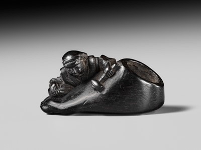 Lot 417 - HOSHUNSAI MASAYUKI: A RARE EBONY WOOD NETSUKE OF A CARVER CHISELING A GIANT FOOT