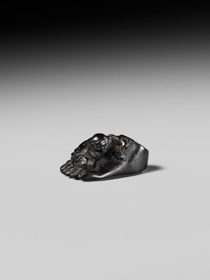 Lot 417 - HOSHUNSAI MASAYUKI: A RARE EBONY WOOD NETSUKE OF A CARVER CHISELING A GIANT FOOT