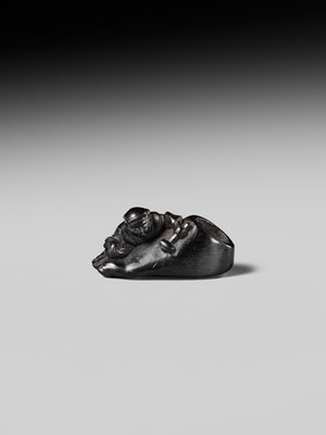 Lot 417 - HOSHUNSAI MASAYUKI: A RARE EBONY WOOD NETSUKE OF A CARVER CHISELING A GIANT FOOT