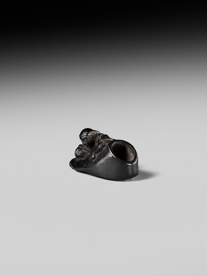 Lot 417 - HOSHUNSAI MASAYUKI: A RARE EBONY WOOD NETSUKE OF A CARVER CHISELING A GIANT FOOT