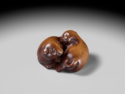 A WOOD NETSUKE OF TWO PUPPIES AT PLAY, ATTRIBUTED TO MASANAO OF KYOTO