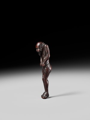A TALL WOOD NETSUKE OF A MAN TYING HIS FUNDOSHI (LOINCLOTH), ATTRIBUTED TO AWATAGUCHI