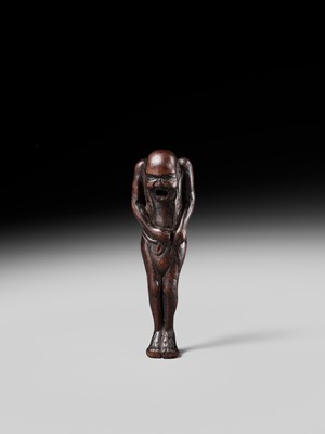 A TALL WOOD NETSUKE OF A MAN TYING HIS FUNDOSHI (LOINCLOTH), ATTRIBUTED TO AWATAGUCHI