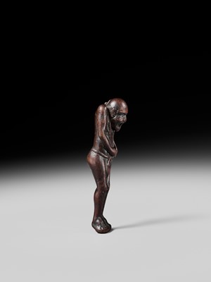 A TALL WOOD NETSUKE OF A MAN TYING HIS FUNDOSHI (LOINCLOTH), ATTRIBUTED TO AWATAGUCHI