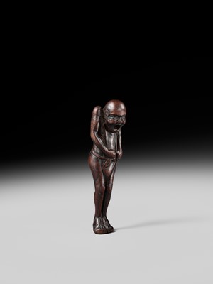 A TALL WOOD NETSUKE OF A MAN TYING HIS FUNDOSHI (LOINCLOTH), ATTRIBUTED TO AWATAGUCHI