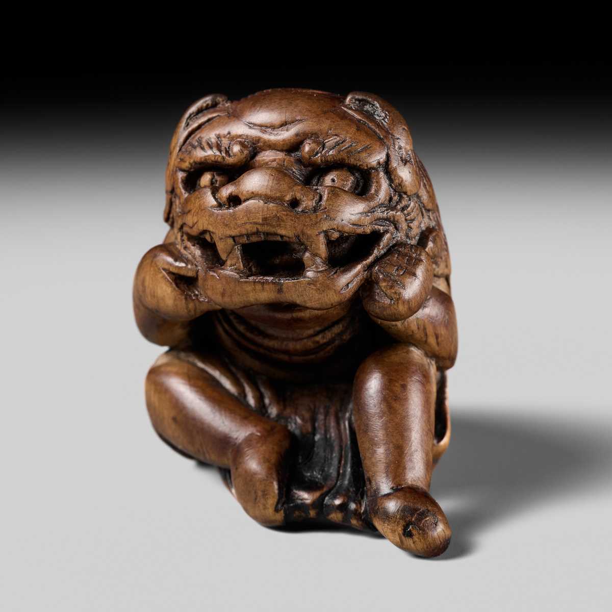 A POWERFUL HINOKI WOOD NETSUKE OF A SHISHIMAI DANCER