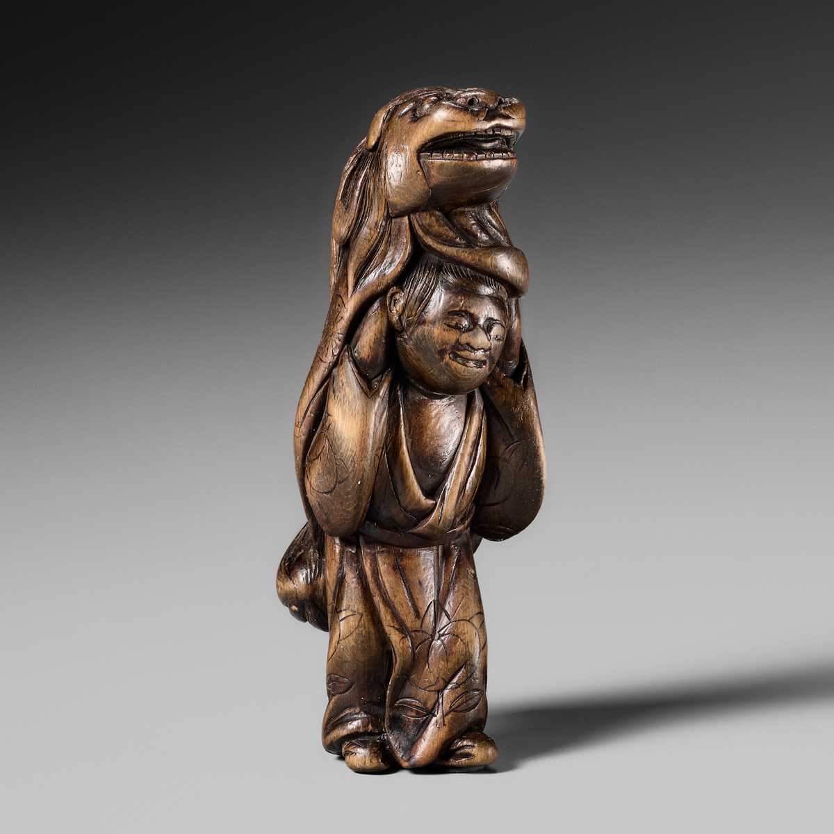 A LARGE HINOKI WOOD NETSUKE OF A SHISHIMAI DANCER