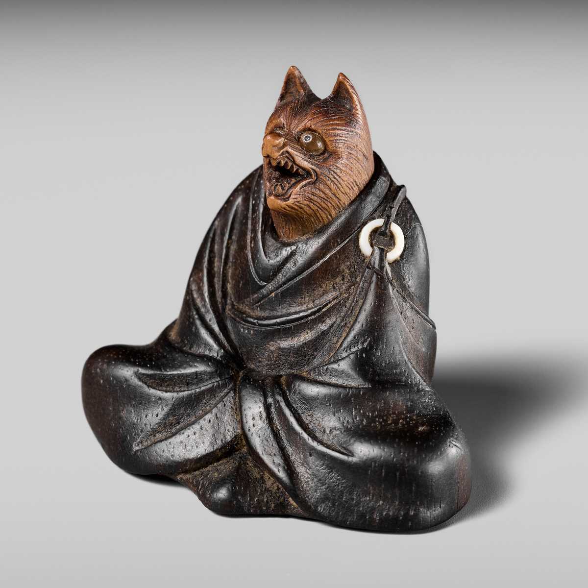 Lot 170 - ANRAKU: A FINE AND HUMOROUS WOOD NETSUKE OF TANUKI DISGUISED AS A PRIEST