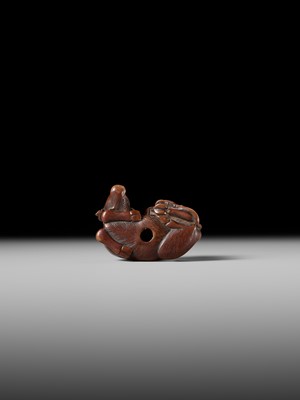 A FINE WOOD NETSUKE OF A HERDBOY SLEEPING ON AN OX