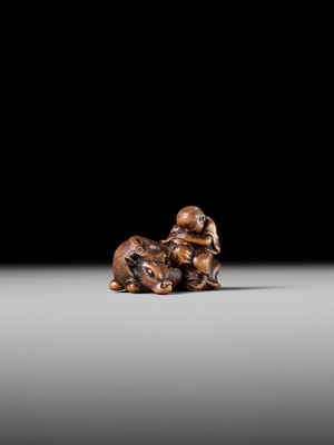 A FINE WOOD NETSUKE OF A HERDBOY SLEEPING ON AN OX