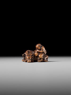 A FINE WOOD NETSUKE OF A HERDBOY SLEEPING ON AN OX