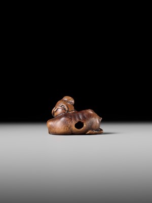 A FINE WOOD NETSUKE OF A HERDBOY SLEEPING ON AN OX