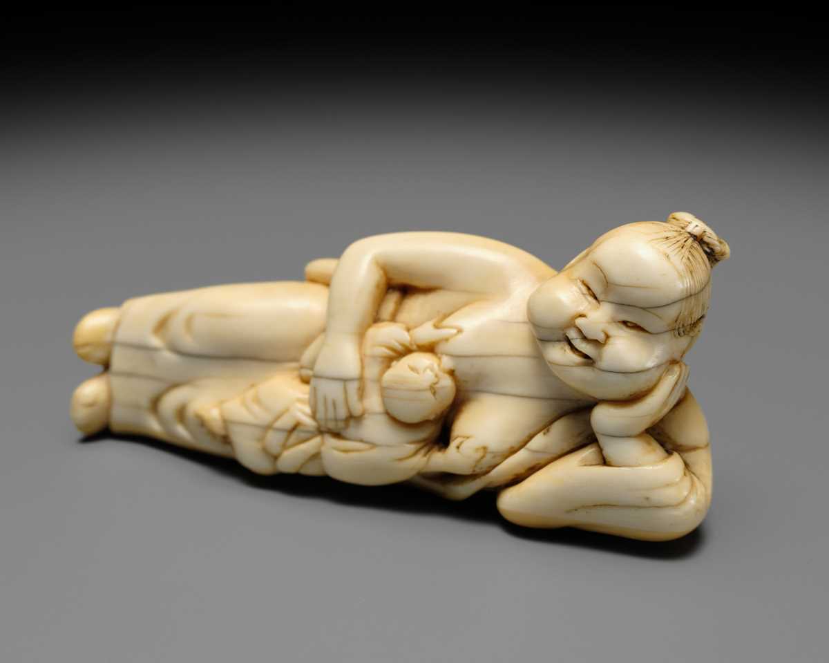 Lot 103 - AN EARLY IVORY NETSUKE OF OKAME WITH CHILD