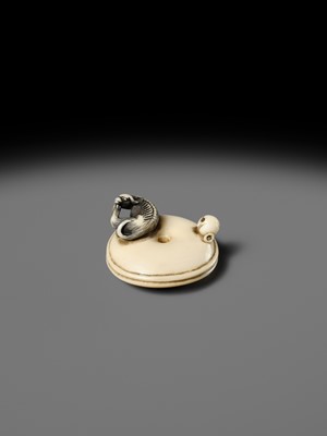 MITSUHARU: AN IVORY NETSUKE OF A DOG ON A CUSHION