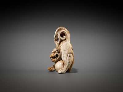 Lot 332 - A RARE IVORY NETSUKE OF A SHISHI WITH A BALL