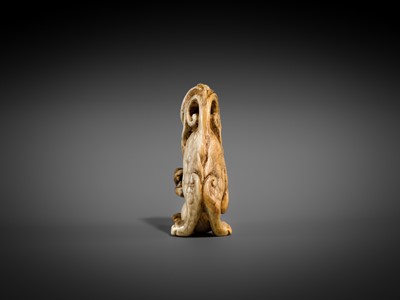 Lot 332 - A RARE IVORY NETSUKE OF A SHISHI WITH A BALL