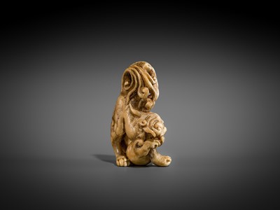 Lot 332 - A RARE IVORY NETSUKE OF A SHISHI WITH A BALL