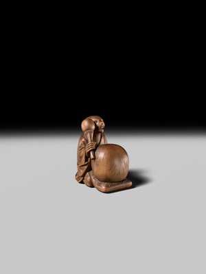 Lot 398 - SUKETADA: AN AMUSING WOOD NETSUKE OF A TANUKI BEATING A MOKUGYO