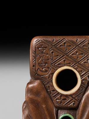 Lot 398 - SUKETADA: AN AMUSING WOOD NETSUKE OF A TANUKI BEATING A MOKUGYO