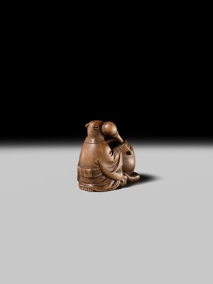 Lot 398 - SUKETADA: AN AMUSING WOOD NETSUKE OF A TANUKI BEATING A MOKUGYO