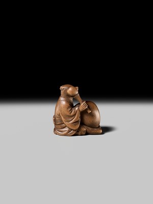 Lot 398 - SUKETADA: AN AMUSING WOOD NETSUKE OF A TANUKI BEATING A MOKUGYO