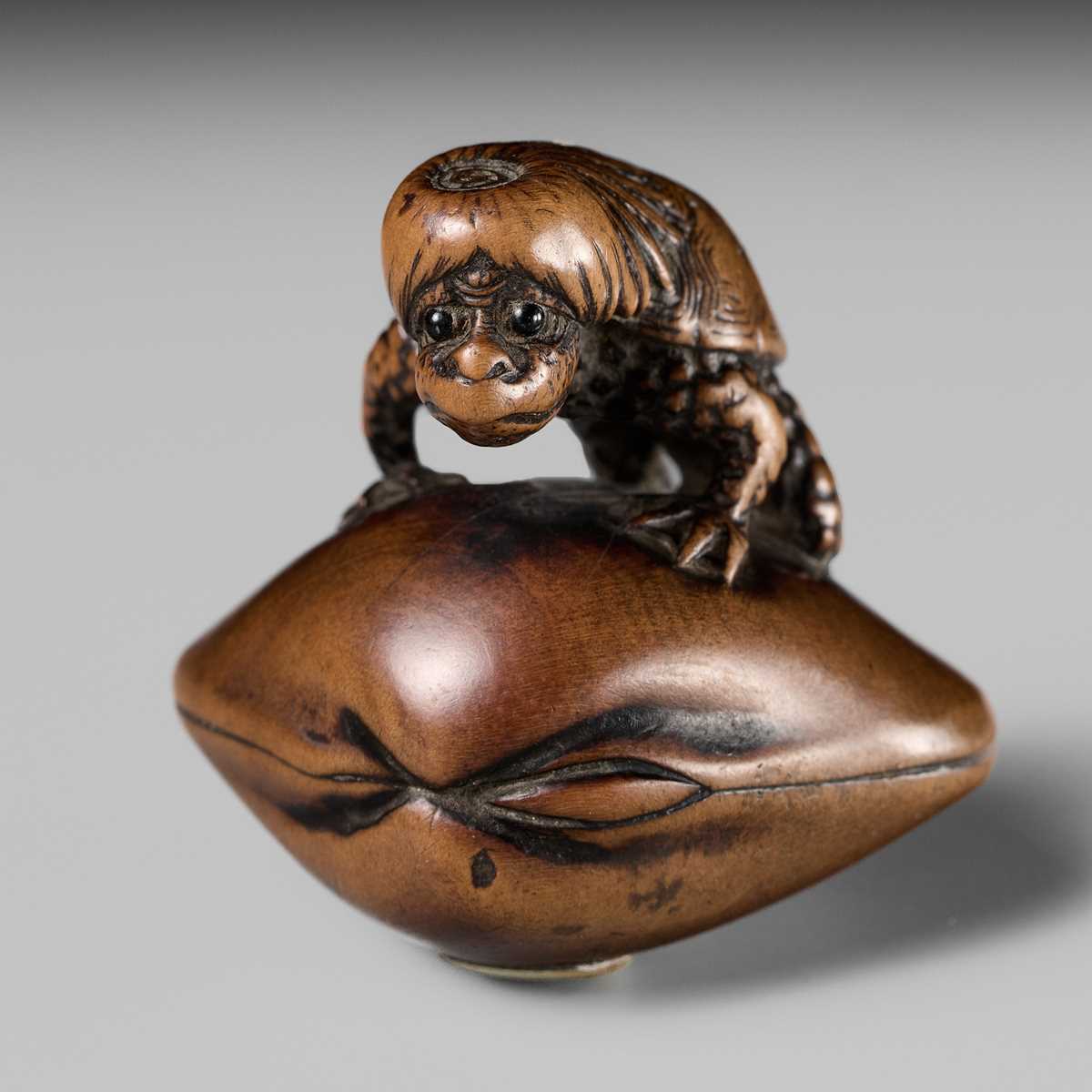 Lot 402 - SUKETADA: A FINE WOOD NETSUKE OF A KAPPA ON HAMAGURI CLAM